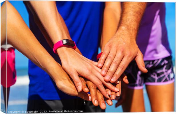 Multi ethnic friends joining hands after beach workout Canvas Print by Spotmatik 