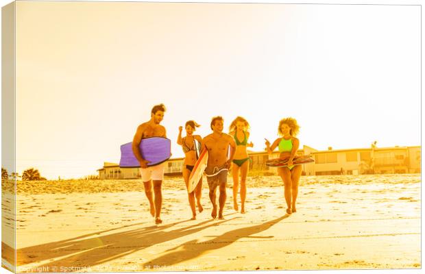 Friends in swimwear running carrying bodyboards on beach Canvas Print by Spotmatik 