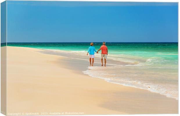 Mature couple paddling on tropical island shoreline Bahamas Canvas Print by Spotmatik 