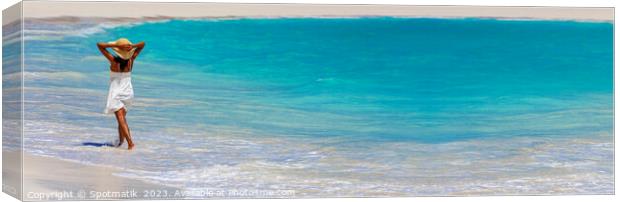 Panoramic ocean with young female walking in waves Canvas Print by Spotmatik 