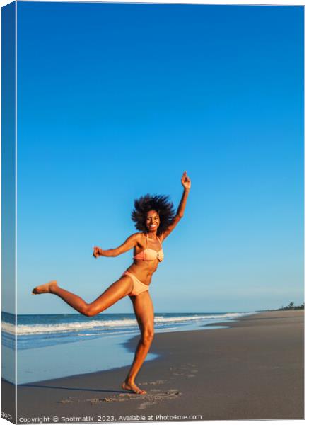 Playful young Afro American woman by the ocean Canvas Print by Spotmatik 