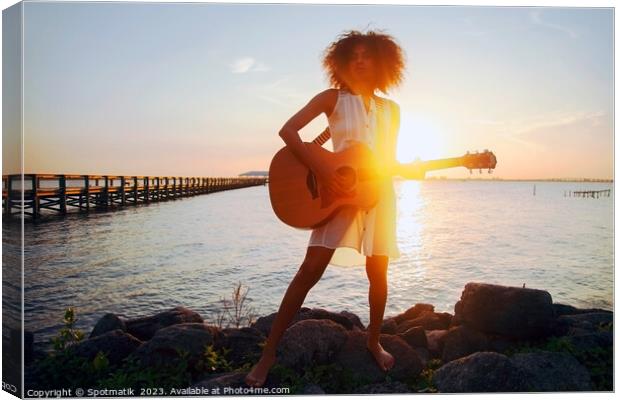 Afro American girl playing guitar with ocean sunset Canvas Print by Spotmatik 