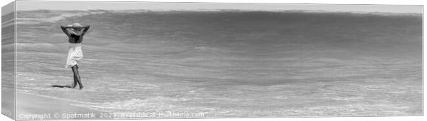 Happy young female walking through waves on beach Canvas Print by Spotmatik 