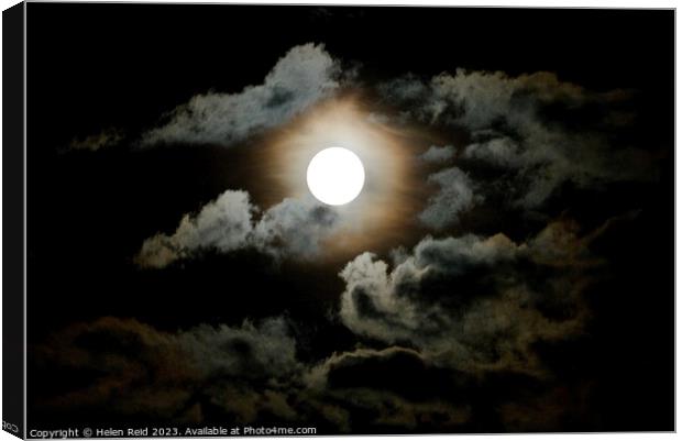 Dark super moon surrounded by clouds Canvas Print by Helen Reid