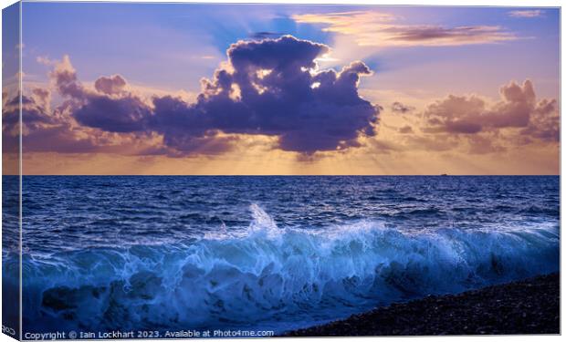 Sunset from Brighton beach with light glistening on the sea spray Canvas Print by Iain Lockhart