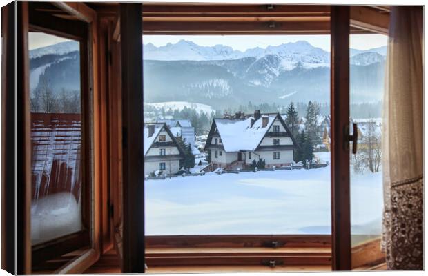 Beautiful view from an open window to a winter vil Canvas Print by Olga Peddi