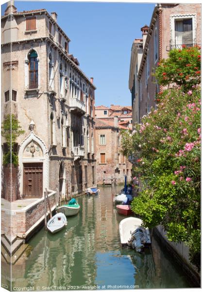 A Venice canal with boats Canvas Print by Sean Tobin