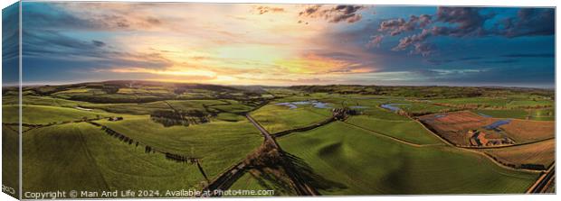 Panoramic view of a lush countryside at sunset with vibrant skies and rolling hills. Canvas Print by Man And Life