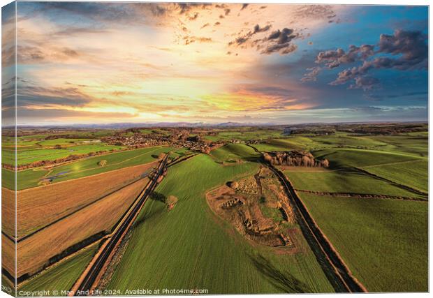 Aerial view of a lush countryside at sunset with vibrant skies and patchwork fields. Canvas Print by Man And Life