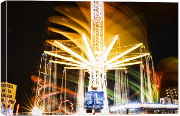 Long exposure of a brightly lit carousel at night, capturing motion blur of spinning lights at a fair. Canvas Print by Man And Life