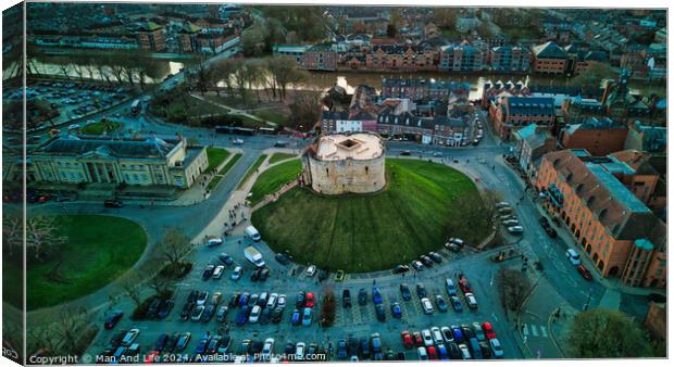 Aerial view of a historic building with a circular shape surrounded by a green lawn, parking area, and cityscape during twilight in York, North Yorkshire Canvas Print by Man And Life