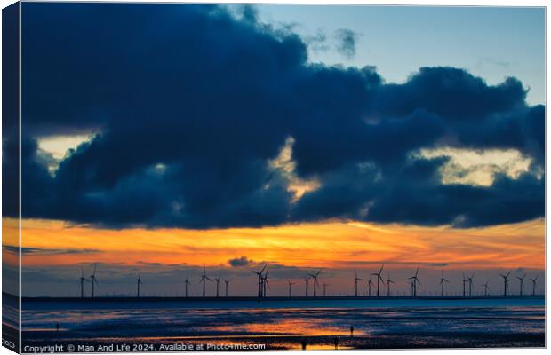 Sunset over sea with silhouette of offshore wind turbines, vibrant sky, and reflection on water in Crosby, England. Canvas Print by Man And Life