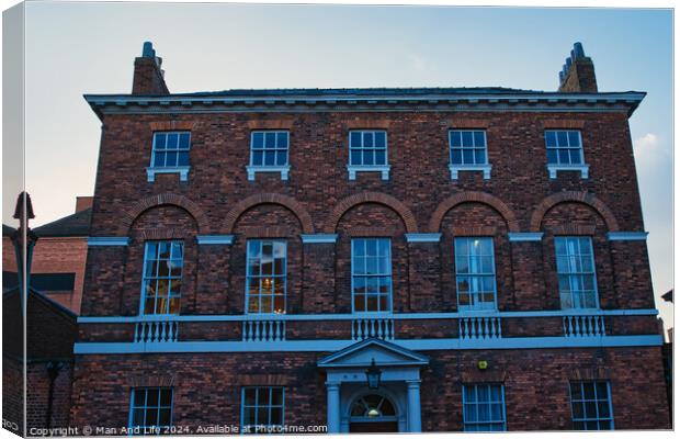 Traditional brick building facade under blue sky at dusk in York, UK. Canvas Print by Man And Life