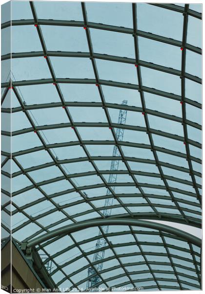 Abstract view of a glass ceiling with a metal frame, showcasing geometric patterns and a clear blue sky in the background. Canvas Print by Man And Life