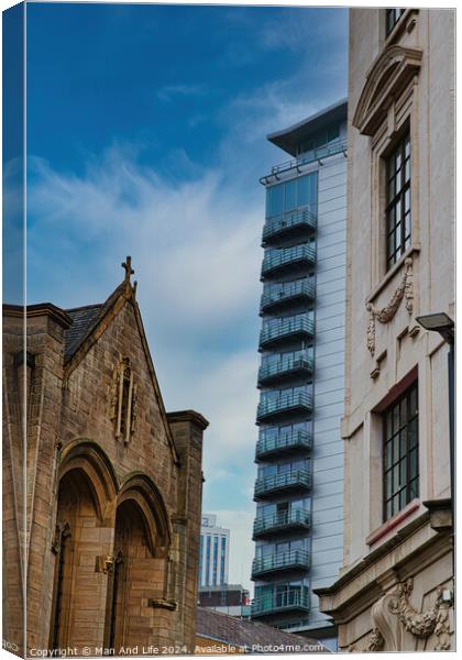 Contrast of old and new architecture with a historic church in the foreground and a modern skyscraper in the background against a blue sky in Leeds, UK. Canvas Print by Man And Life