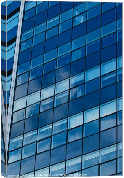 Modern glass building facade reflecting blue sky with clouds, architectural details and textures, urban background in Leeds, UK. Canvas Print by Man And Life