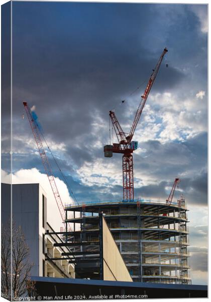 Construction site with cranes against a dramatic cloudy sky, symbolizing development and architecture in Liverpool, UK. Canvas Print by Man And Life
