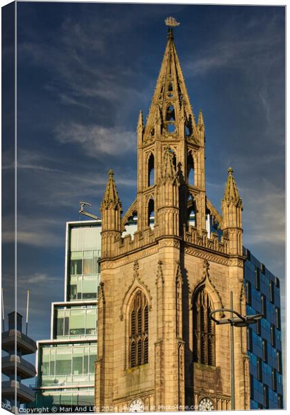 Gothic church spire against a blue sky with modern buildings in the background in Liverpool, UK. Canvas Print by Man And Life