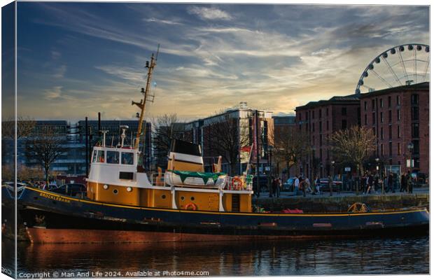 Tugboat in city harbor at sunset with ferris wheel and buildings in background in Liverpool, UK. Canvas Print by Man And Life