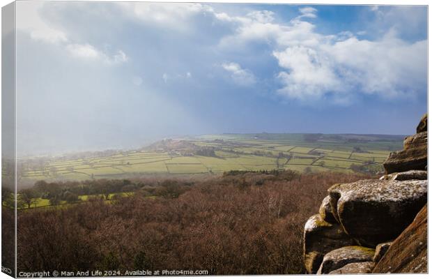 Scenic view of a sunlit countryside landscape with rocky foreground under a dramatic sky at Brimham Rocks, in North Yorkshire Canvas Print by Man And Life