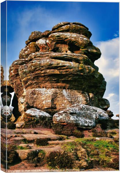 Majestic rock formation under blue sky with clouds, showcasing natural erosion and geological layers at Brimham Rocks, in North Yorkshire Canvas Print by Man And Life