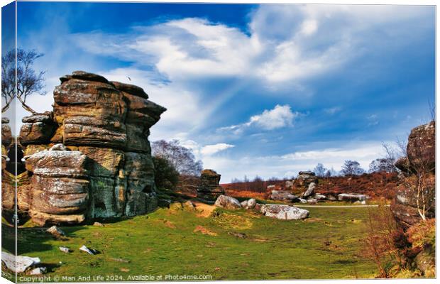 Scenic view of rock formations and lush greenery under a blue sky with wispy clouds at Brimham Rocks, in North Yorkshire Canvas Print by Man And Life