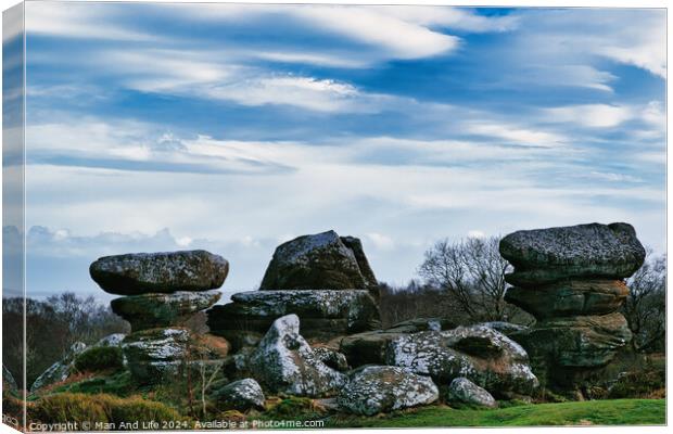 Scenic view of unique rock formations with moss under a cloudy sky in a lush green landscape at Brimham Rocks, in North Yorkshire Canvas Print by Man And Life