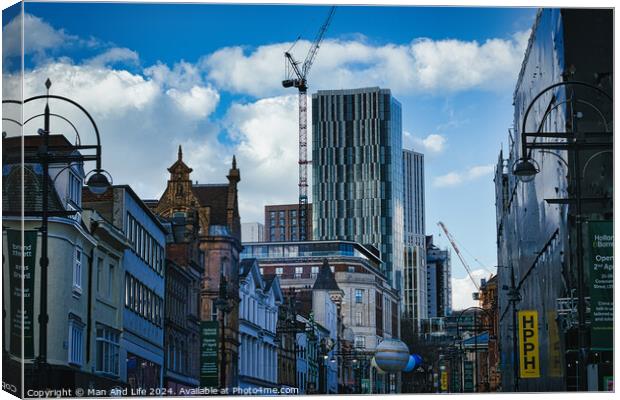Urban cityscape with historic buildings and modern skyscraper under construction against a blue sky with clouds in Leeds, UK. Canvas Print by Man And Life