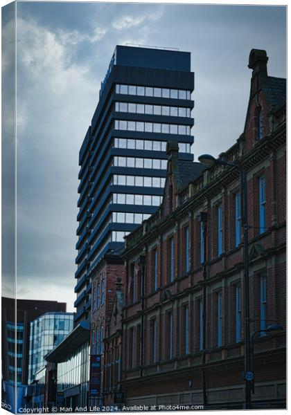 Contrast of old and new architecture with a modern skyscraper towering behind a classic brick building under a cloudy sky in Leeds, UK. Canvas Print by Man And Life
