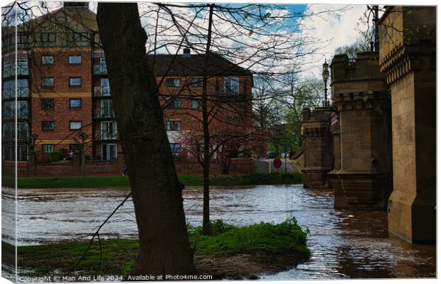 Urban riverside scene with swollen river waters, lush greenery, and a backdrop of modern residential buildings, showcasing the contrast between nature and urban development in York, North Yorkshire, England. Canvas Print by Man And Life