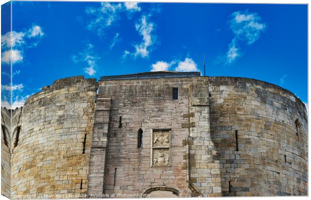 Medieval stone fortress against a vibrant blue sky with fluffy clouds, showcasing ancient architecture and historical military construction in York, North Yorkshire, England. Canvas Print by Man And Life