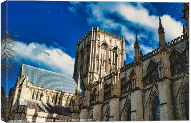 Majestic Gothic cathedral against a blue sky with fluffy clouds, showcasing intricate architecture and historical grandeur in York, North Yorkshire, England. Canvas Print by Man And Life