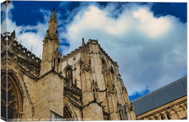 Majestic gothic cathedral facade against a dramatic sky with fluffy clouds, showcasing intricate architectural details and historical religious significance in York, North Yorkshire, England. Canvas Print by Man And Life