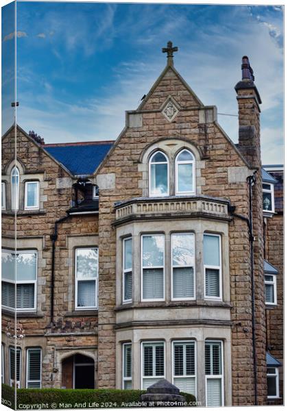 Victorian-style stone building with a gabled roof and bay windows under a blue sky with clouds, showcasing classic architectural details and craftsmanship in Harrogate, North Yorkshire. Canvas Print by Man And Life