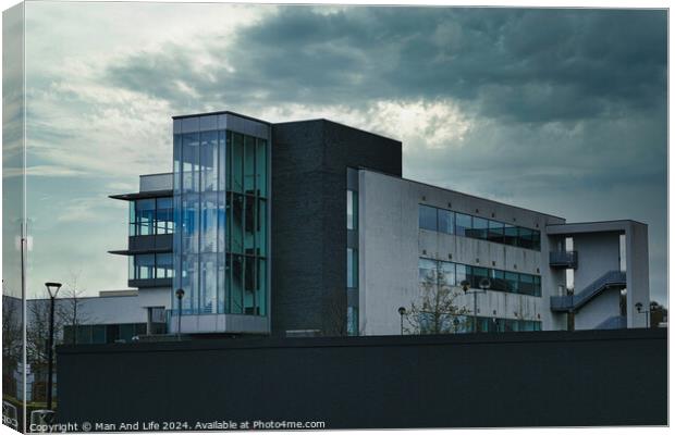 Modern office building against a dramatic cloudy sky, showcasing contemporary architecture with a mix of glass and concrete elements. Canvas Print by Man And Life