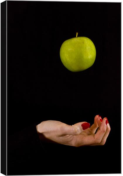 Female hand throwing a green apple Canvas Print by Gabor Pozsgai