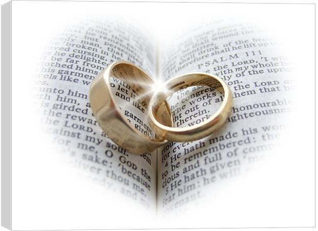 Wedding rings on an open Bible Canvas Print by Pete Holloway