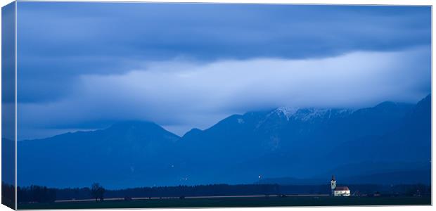 In the shadow of a mighty mountain range Canvas Print by Ian Middleton