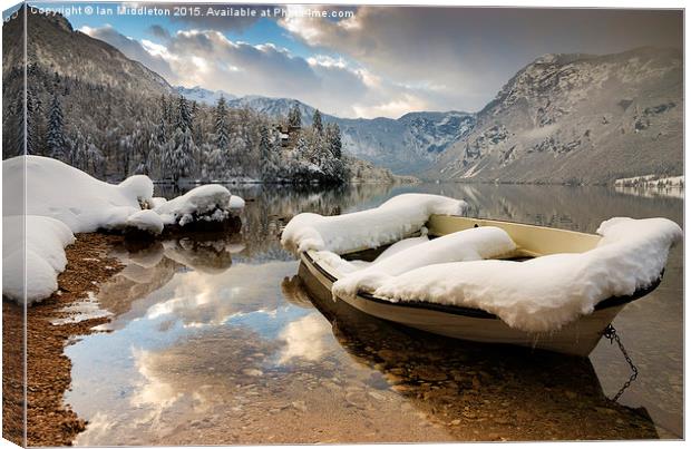 Snow covered boat on Lake Bohinj in Winter Canvas Print by Ian Middleton