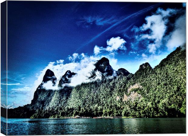 Huts dwarfed by mountains Canvas Print by Simon Joshua Peel