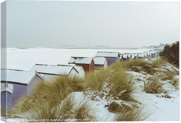 Sand dunes and beach huts covered in snow. Canvas Print by Liam Grant