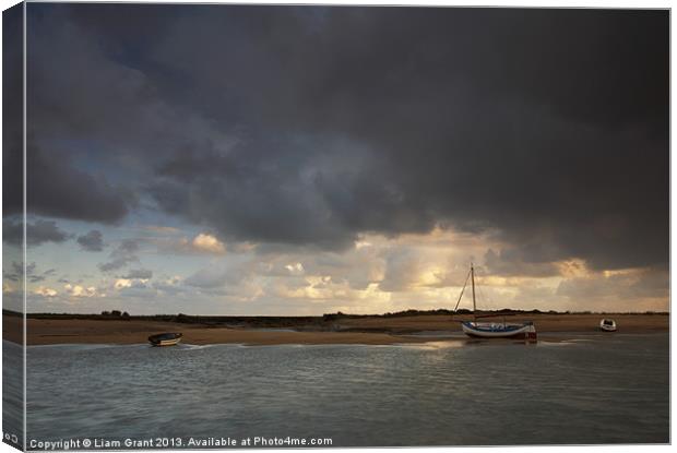 Storm over boats, Burnham Overy Staithe. Canvas Print by Liam Grant