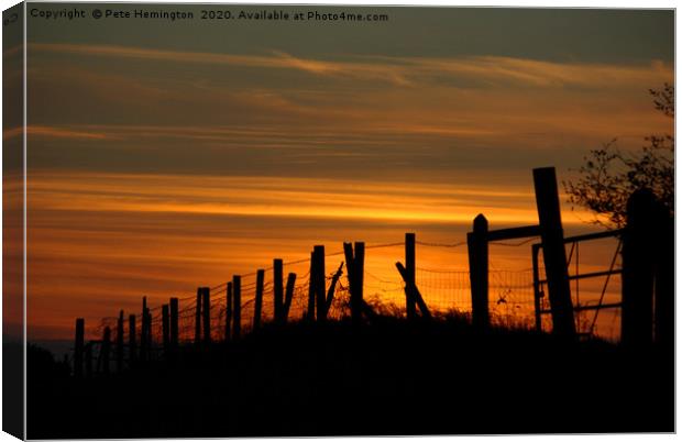 Sunset through the fence Canvas Print by Pete Hemington