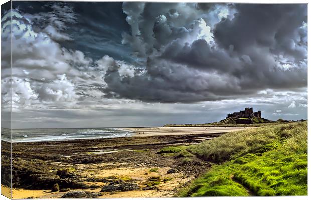 Dramatic skys over Bamburgh Castle and beach Canvas Print by Kevin Tate