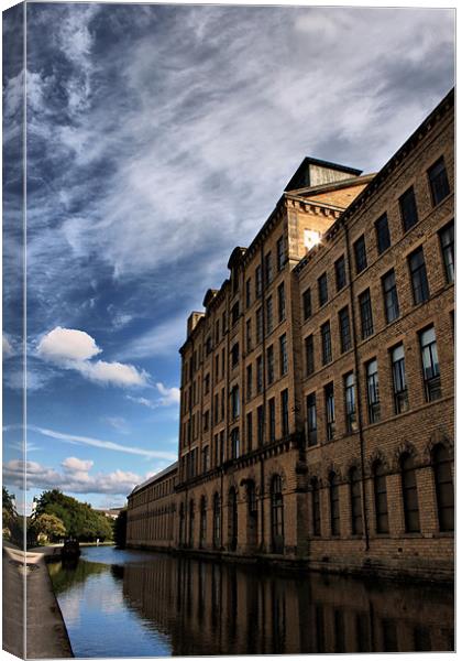 salts mill towering over leeds liverpool canal Canvas Print by simon sugden