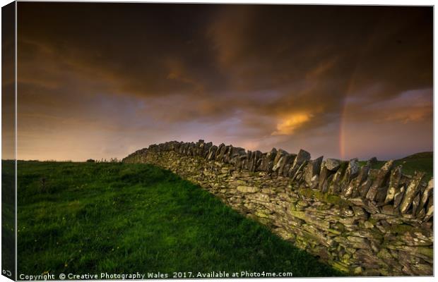A stone wall and rainbow Canvas Print by Creative Photography Wales