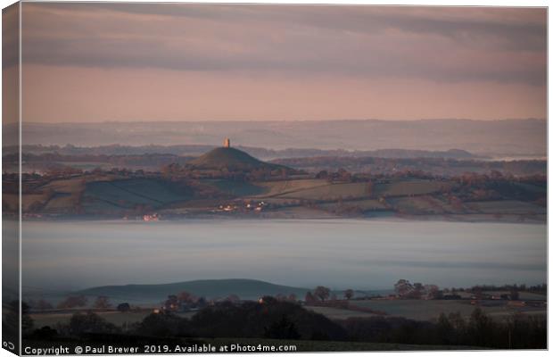 Glastonbury Tor at Sunrise surrounded by mist  Canvas Print by Paul Brewer