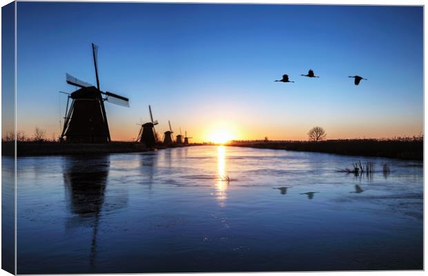 Heron flying over the frozen Kinderdijk Sunrise Canvas Print by Ankor Light