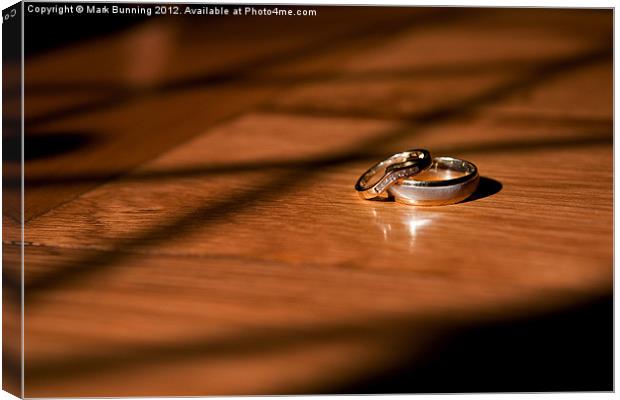 Wedding rings on a table Canvas Print by Mark Bunning