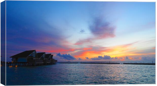 Sunset sea view over Maldives water bungalows  Canvas Print by mark humpage